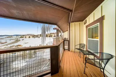 a balcony with two chairs and a large window at Base Camp One 412 in Granby