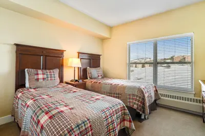 two beds in a room with a window at Base Camp One 412 in Granby