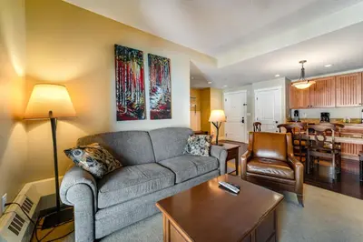 a living room with a couch and a table at Base Camp One 412 in Granby