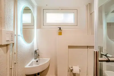 a white bathroom with a sink and a window at Sloans Lake Basement Suite in Denver