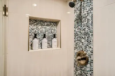 a bathroom with four bottles on a shelf next to a shower at Sloans Lake Basement Suite in Denver