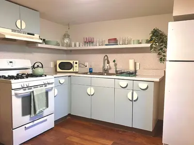 a kitchen with white cabinets and a white stove top oven at Sloans Lake Basement Suite in Denver
