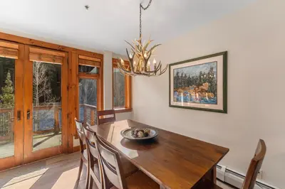 a dining room with a table and chairs and a chandelier at Timbers 3080 in Keystone