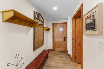 a hallway with a wooden bench and a door at Timbers 3080 in Keystone