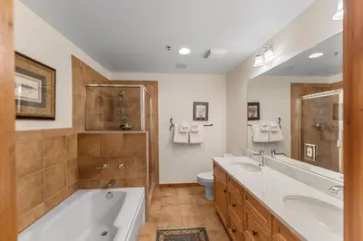 a bathroom with two sinks and a tub and a toilet at Timbers 3080 in Keystone