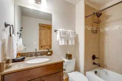 a bathroom with a sink and a toilet and a mirror at Less Than 5 Mi to Winter Park Family Base Camp with Hot Tub in Fraser