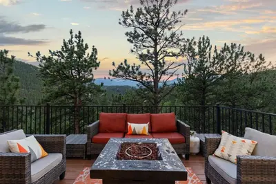 a patio with a couch and a table on a balcony at Mountain View Retreat- Private Hot Tub & Views in Bailey