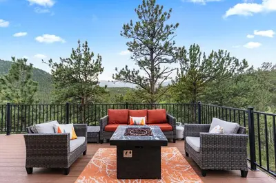 a patio with couches and a coffee table on a deck at Mountain View Retreat- Private Hot Tub & Views in Bailey