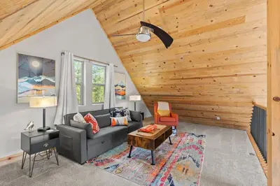 a living room with a couch and a table at Mountain View Retreat- Private Hot Tub & Views in Bailey