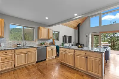 a large kitchen with wooden cabinets and a large island at Mountain View Retreat- Private Hot Tub & Views in Bailey