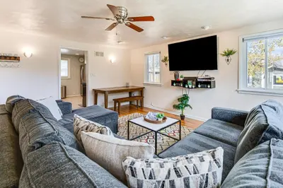 a living room with a blue couch and a flat screen tv at Walk to Old Town Lafayette! Cozy Couples Escape in Lafayette