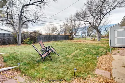 a park bench sitting in the grass in a yard at Walk to Old Town Lafayette! Cozy Couples Escape in Lafayette