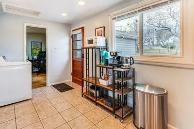 a living room with a kitchen with a microwave at Walk to Old Town Lafayette! Cozy Couples Escape in Lafayette