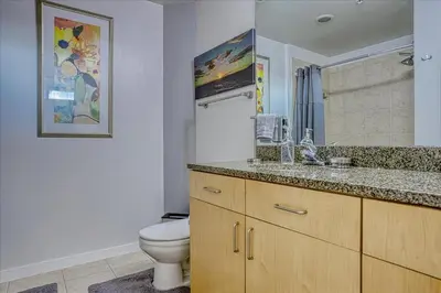 a bathroom with a toilet and a sink and a mirror at Sunset View in Denver