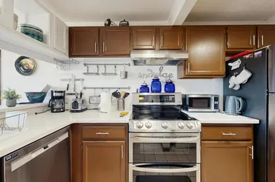 a kitchen with wooden cabinets and a stove top oven at Granby Vista Getaway in Granby