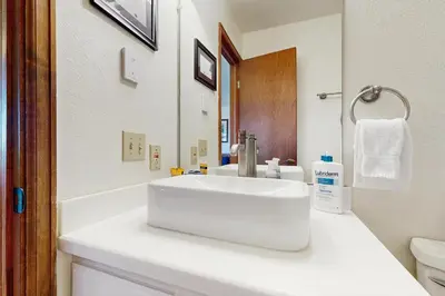 a white bathroom with a sink and a mirror at Granby Vista Getaway in Granby