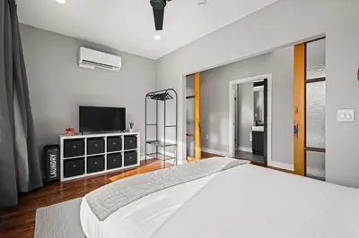 a bedroom with a large white bed and a flat screen tv at Downtown Denver Suite - Skyline Views in Denver