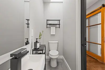 a white bathroom with a toilet and a sink at Downtown Denver Suite - Skyline Views in Denver