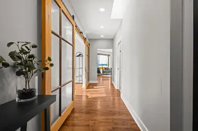 a hallway of a house with white walls and wood floors at Downtown Denver Suite - Skyline Views in Denver
