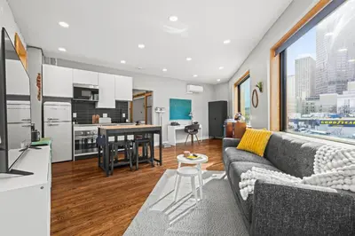 a living room with a couch and a kitchen at Downtown Denver Suite - Skyline Views in Denver