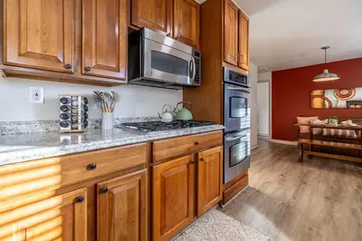 a kitchen with wooden cabinets and stainless steel appliances at Movie Theater Game Console Arcade Fire Pit BBQ in Westminster