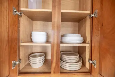 a cabinet filled with white bowls and plates at Movie Theater Game Console Arcade Fire Pit BBQ in Westminster