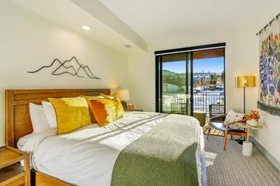 a bedroom with a bed with yellow pillows and a window at Timber Fox 2207 condo in Winter Park