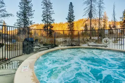a hot tub with a fence and trees at Timber Fox 2207 condo in Winter Park