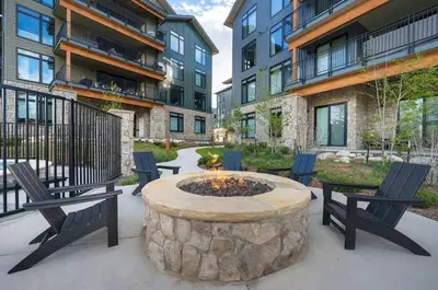 a patio with chairs and a fire pit in front of a building at Timber Fox 2207 condo in Winter Park