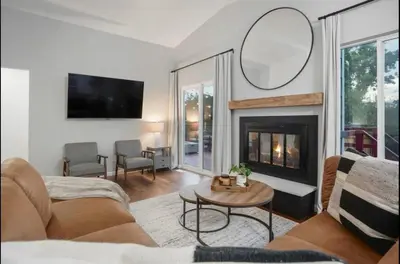 a living room with a fireplace and a mirror at Colorado Retreat in Westminster