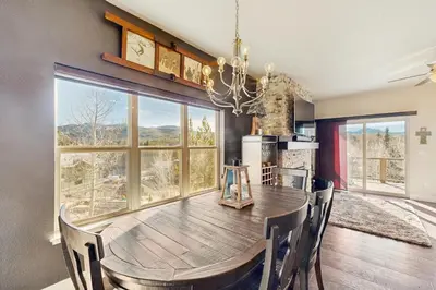 a dining room with a table and a large window at Lookout Point in Fraser