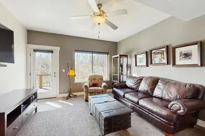 a living room with a leather couch and a ceiling fan at Lookout Point in Fraser