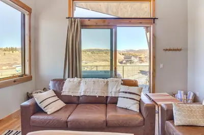 a living room with a couch and a large window at 5 Mi to Winter Park Skiing and Dtwn Mtn-View Condo in Fraser