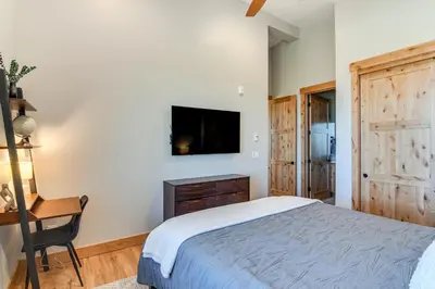 a bedroom with a bed and a desk and a tv at 5 Mi to Winter Park Skiing and Dtwn Mtn-View Condo in Fraser