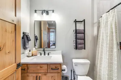 a bathroom with a sink and a toilet and a mirror at 5 Mi to Winter Park Skiing and Dtwn Mtn-View Condo in Fraser