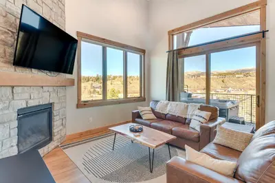 a living room with a couch and a fireplace at 5 Mi to Winter Park Skiing and Dtwn Mtn-View Condo in Fraser