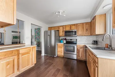 a kitchen with wooden cabinets and a stainless steel refrigerator at Longmont board games, beds, and boats - 4BR in Longmont