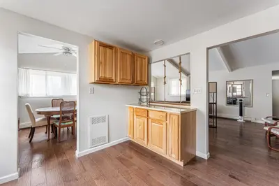 a kitchen with wooden cabinets and a dining room at Longmont board games, beds, and boats - 4BR in Longmont