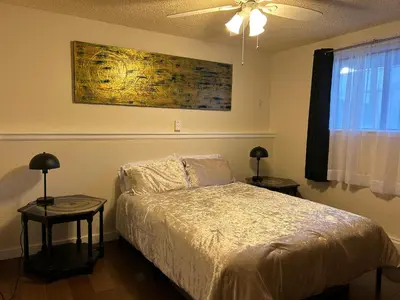 a bedroom with a bed with two tables and a ceiling fan at Longmont board games, beds, and boats - 2BR in Longmont