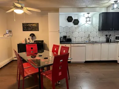 a kitchen with a dining table and red chairs at Longmont board games, beds, and boats - 2BR in Longmont