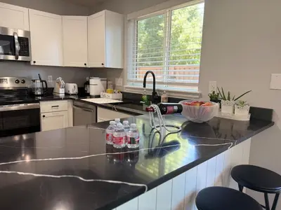 a kitchen with bottles of water on a counter at CENTRAL DENVER FAMILY HOMe in Denver