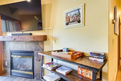a living room with a fireplace and a wooden table at Family Ski Trip! Upscale Keystone Condo Near Lift in Dillon