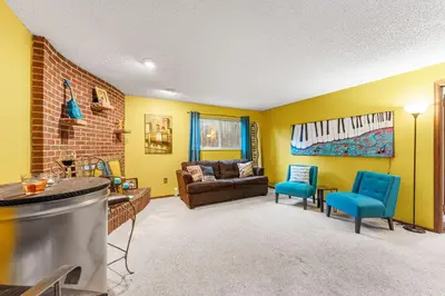a living room with yellow walls and a couch and chairs at Steps to Lake Mcintosh, Basement 1BR in Longmont