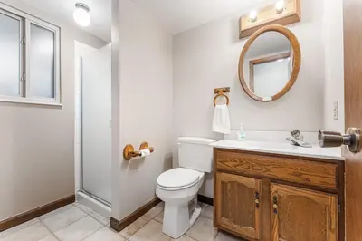 a bathroom with a toilet and a sink and a mirror at Steps to Lake Mcintosh, Basement 1BR in Longmont