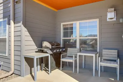 a patio with a grill and two chairs and a window at Walkable Condo 5 Mi to Winter Park Resort! in Fraser