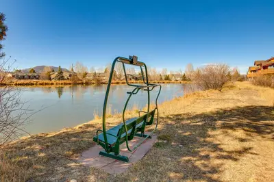 a green park bench next to a body of water at Walkable Condo 5 Mi to Winter Park Resort! in Fraser