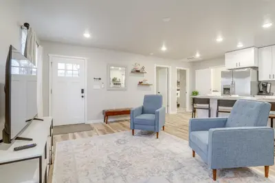 a living room with two blue chairs and a kitchen at Modern and Pet-Friendly! Northern Colorado Retreat