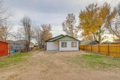 a small house in a yard next to a fence at Modern and Pet-Friendly! Northern Colorado Retreat