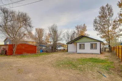 a small house in a yard next to a fence at Modern and Pet-Friendly! Northern Colorado Retreat