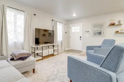 a living room with blue chairs and a tv at Modern and Pet-Friendly! Northern Colorado Retreat